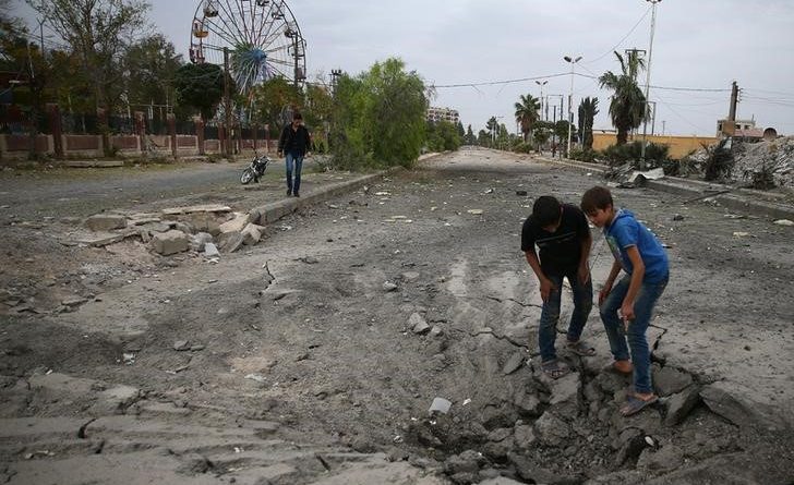 ボーイズは包囲反乱上の遊び場近く空爆がダマスカスでDoumaの町、東Ghoutaを開催した後、地面に穴を検査シリア、10月27日、2016年ロイター/ Bassam Khabieh