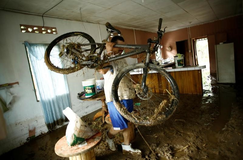 A man removes a bicycle from his house, which was was flooded by heavy rains caused by Hurricane Otto in Guayabo de Bagaces, Costa Rica November 25, 2016. REUTERS/ Juan Carlos Ulate