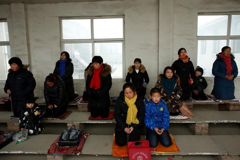 People attend Sunday service at a makeshift, tin-roofed church in Youtong village, China, December 11, 2016. Picture taken December 11, 2016.   REUTERS/Thomas Peter