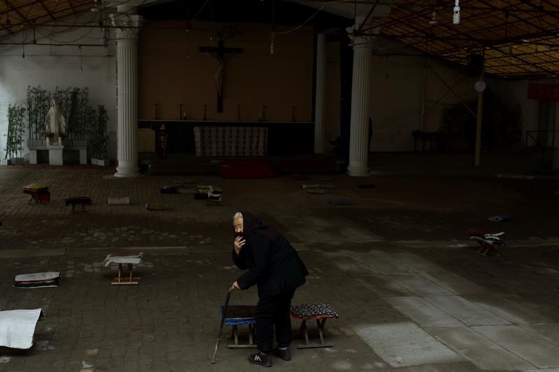 A woman arrives for Sunday service at a makeshift, tin-roofed church in Youtong village, China, December 11, 2016. Picture taken December 11, 2016. REUTERS/Thomas Peter