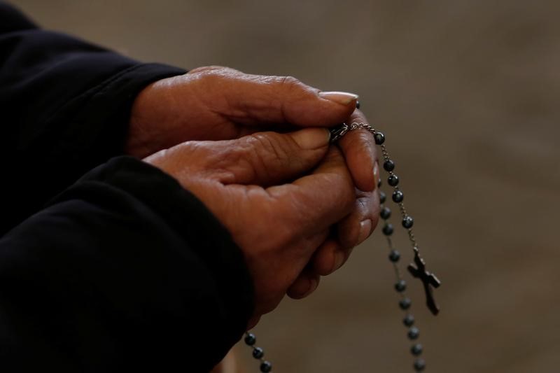 A man holds a rosary during Sunday service at a makeshift, tin-roofed church in Youtong village, Hebei Province, China, December 11, 2016. Picture taken December 11, 2016.   REUTERS/Thomas Peter