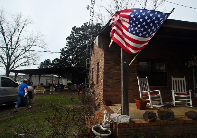 Margie Peters heads to check on her baby goats as a tattered flag stands on her porch after a deadly storm hit Rehobeth, Alabama, U.S., January 3, 2017. REUTERS/Phil Sears