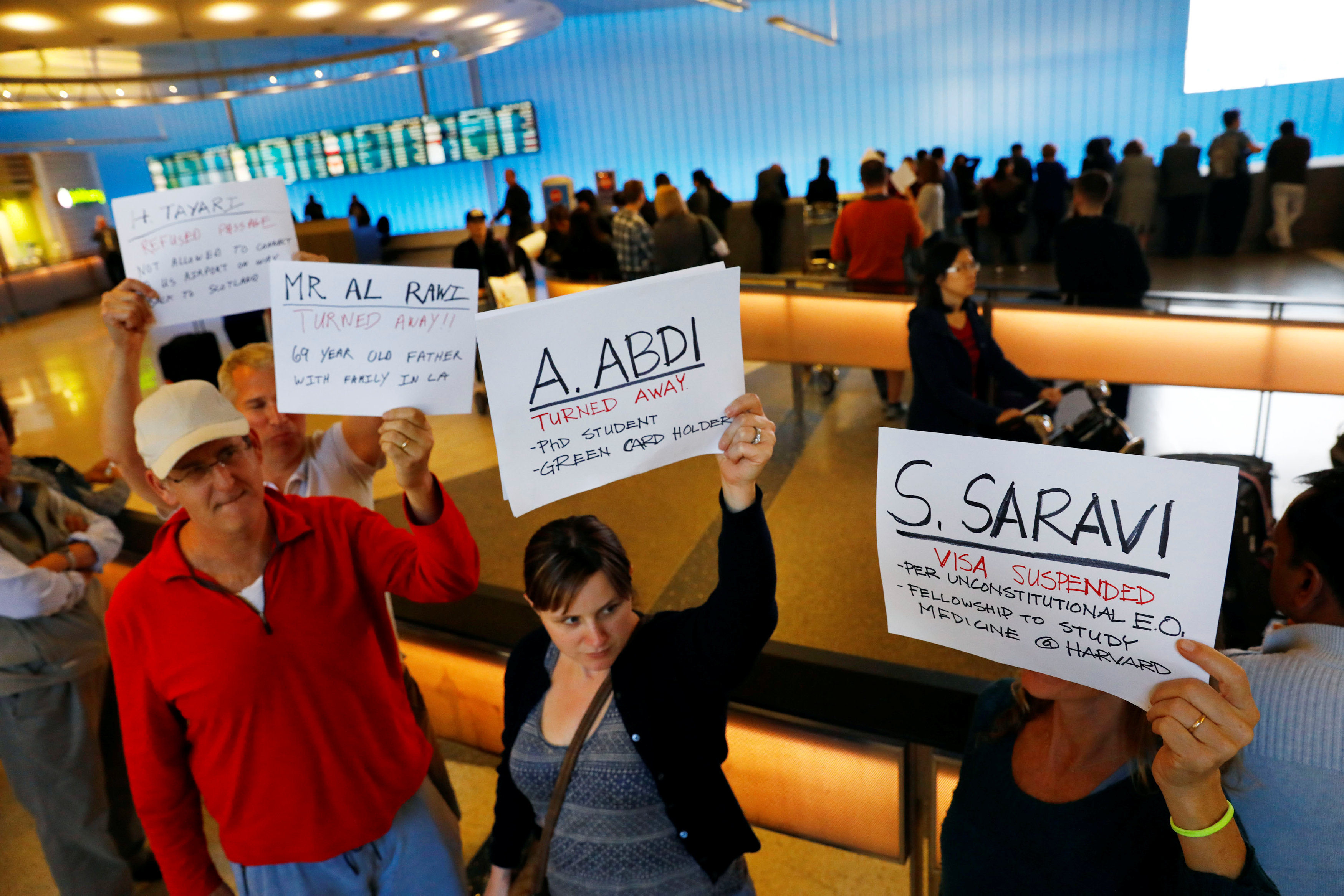 People hold signs with the names of people detained and denied entry in protest of Donald Trump's travel ban at Los Angeles International Airport (LAX) in Los Angeles, California, U.S., January 28, 2017.  REUTERS/Patrick T. Fallon