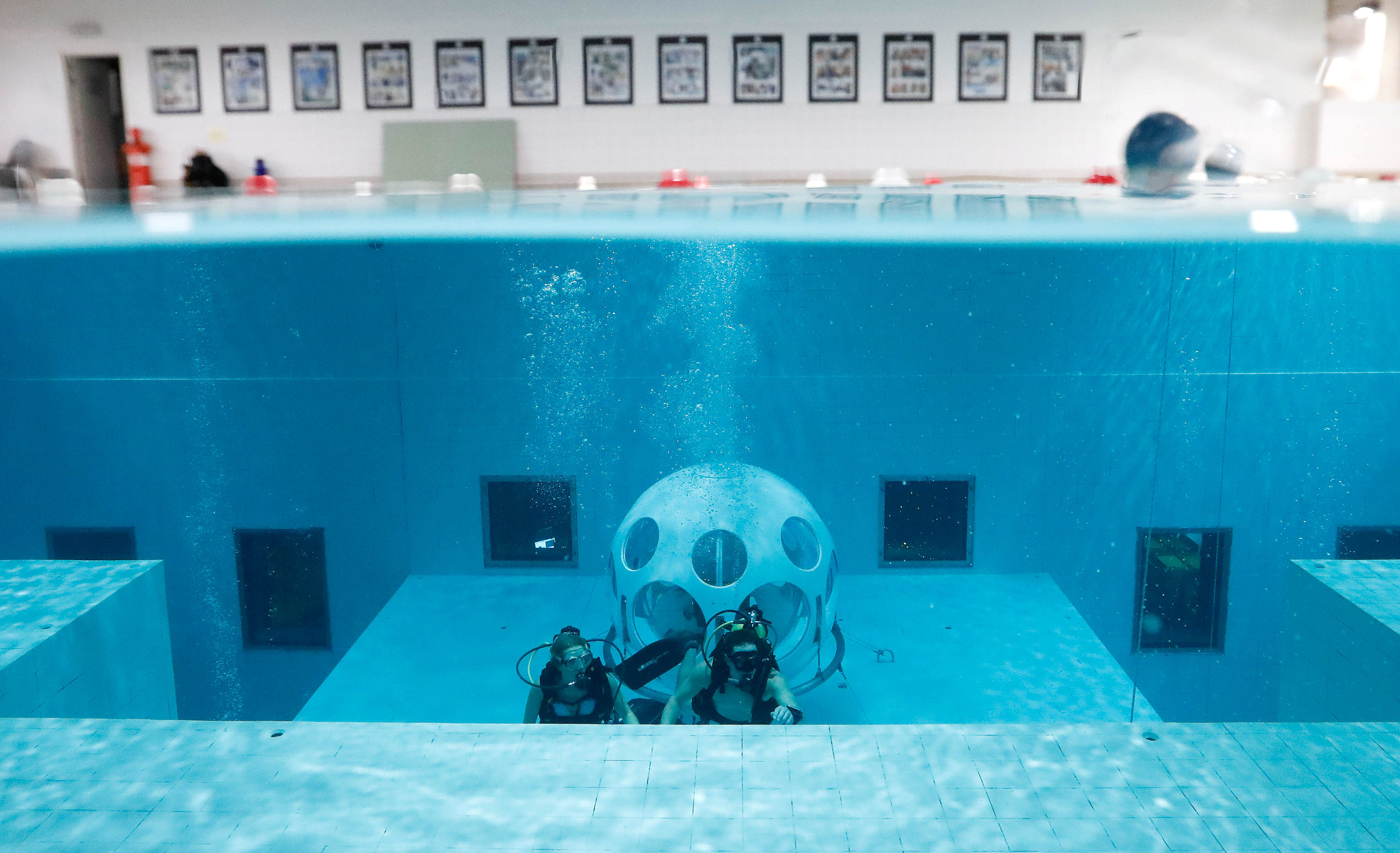 Belgians Florence Lutje Spelberg and Nicolas Mouchart dive next to "The Pearl", a spheric dining room placed 5 metres underwater in the NEMO33 diving center, one of the world's deepest pools (33 metre/36 yards) built to train professional divers, before enjoying a meal inside, in Brussels, Belgium January 30, 2017. Picture taken January 30, 2017   REUTERS/Yves Herman