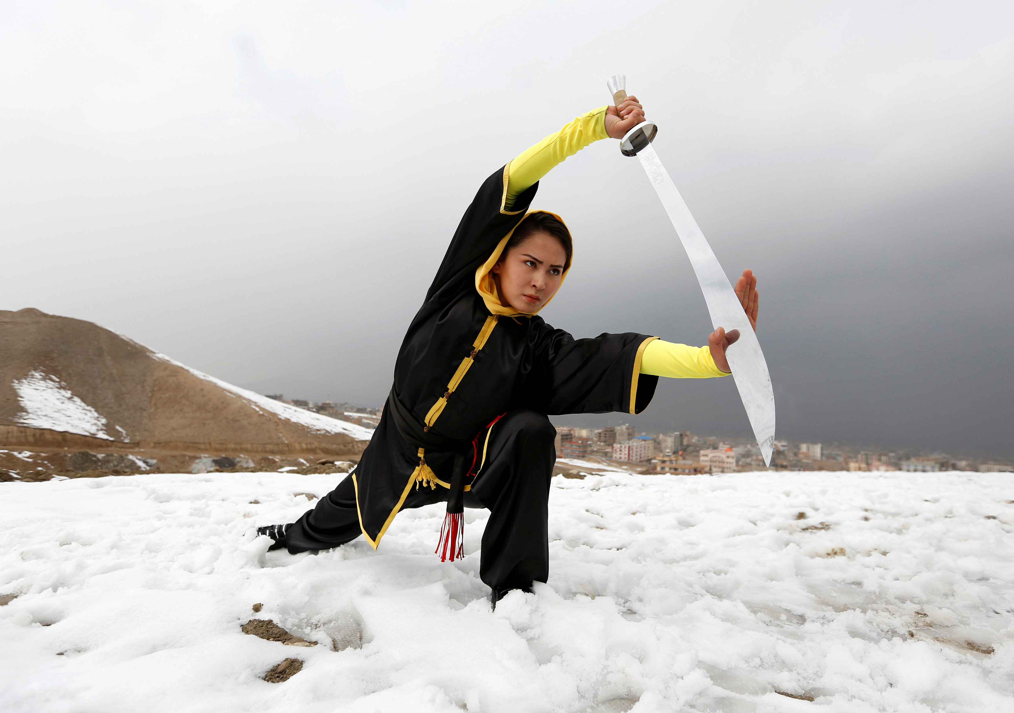 Sima Azimi, 20, a trainer at the Shaolin Wushu club, shows her Wushu skills to other students on a hilltop in Kabul, Afghanistan January 29, 2017. REUTERS/Mohammad Ismail
