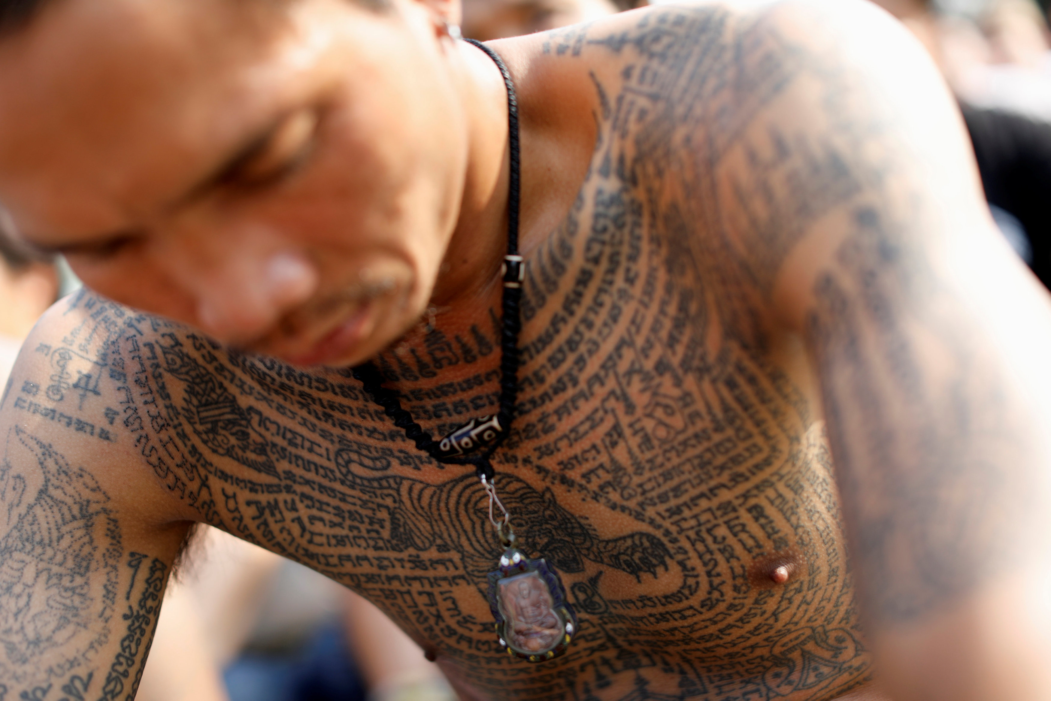 A devotee attends the religious tattoo festival at Wat Bang Phra, where they come to recharge the power of their sacred tattoos, in Nakhon Pathom province, Thailand, March 11, 2017. REUTERS/Jorge Silva