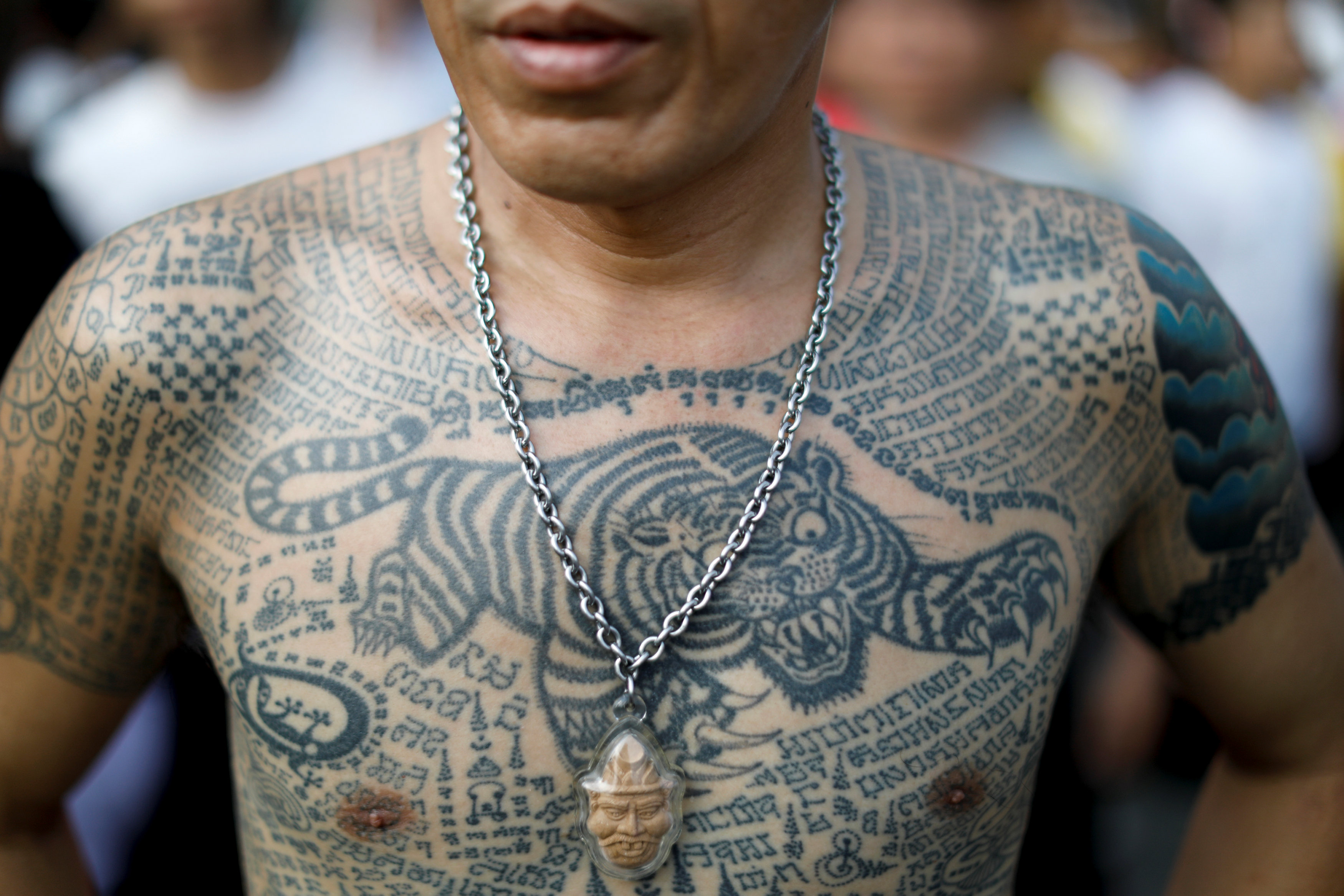 A devotee attends the religious tattoo festival at Wat Bang Phra, where they come to recharge the power of their sacred tattoos, in Nakhon Pathom province, Thailand, March 11, 2017. REUTERS/Jorge Silva