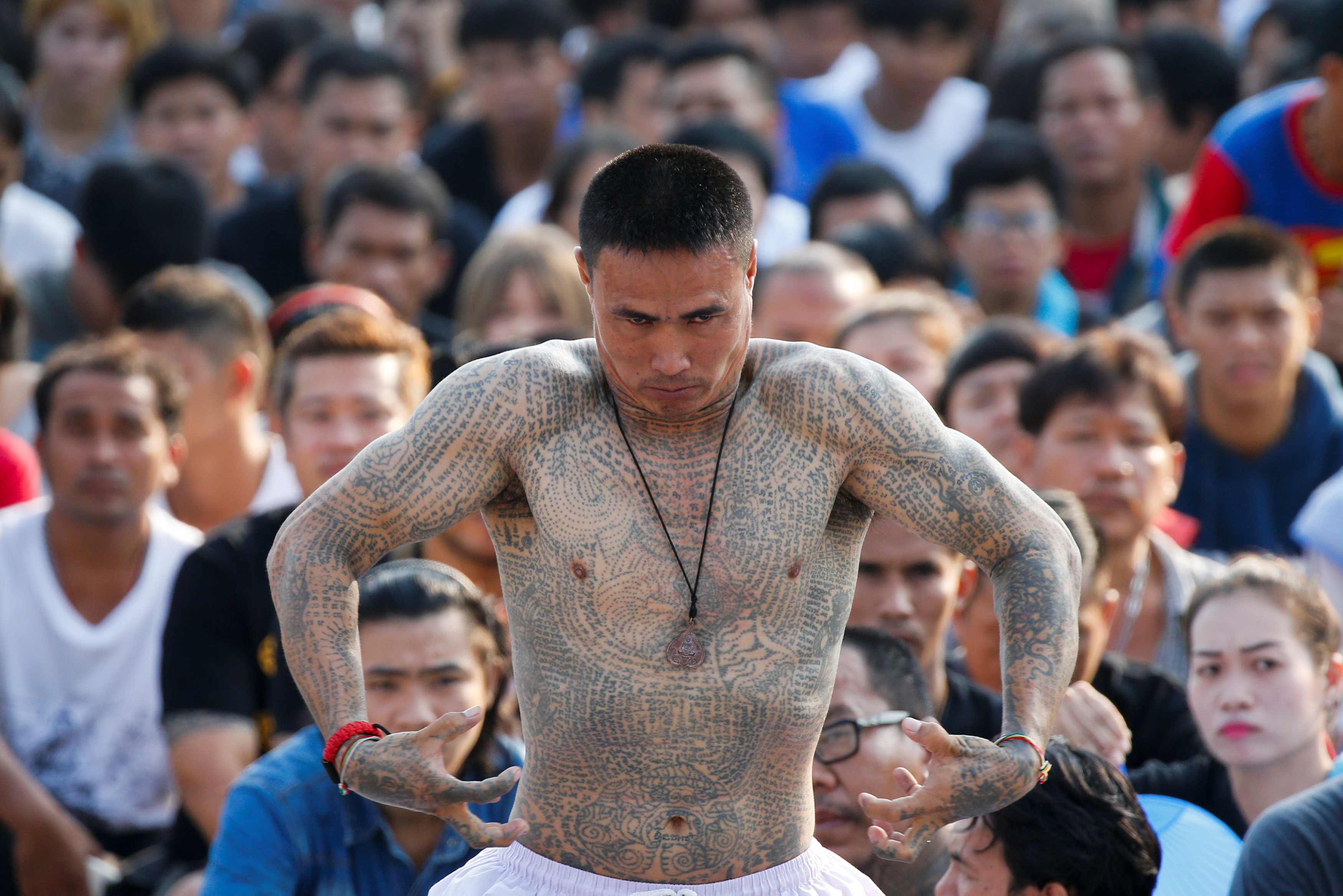 A devotee in trance mimics a beast during a religious tattoo festival at Wat Bang Phra, where devotees come to recharge the power of their sacred tattoos, in Nakhon Pathom province, Thailand, March 11, 2017. REUTERS/Jorge Silva