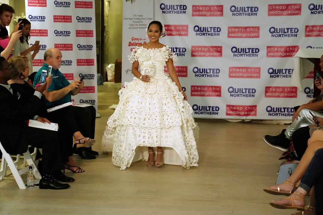 A model presents a wedding dress made out of toilet paper during a fashion show. REUTERS/Carlo Allegri