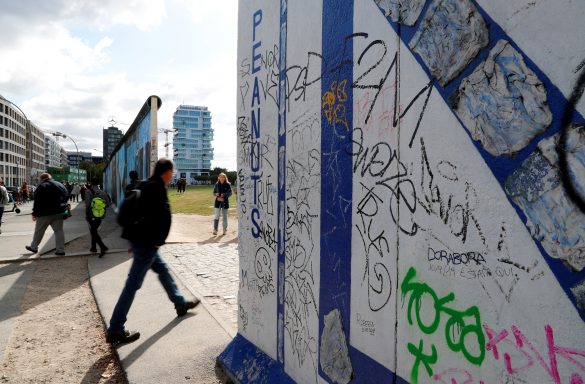 FILE PHOTO: A pedestrian walks past segments of the East Side Gallery, the largest remaining part of the former Berlin Wall, in Berlin, Germany, September 19, 2019. REUTERS/Fabrizio Bensch/File Photo