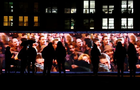People stand in front of a projection on the East Side Gallery, the largest remaining part of the former Berlin Wall, in Berlin, Germany, November 4, 2019. On November 9th Germany will mark the 30th anniversary of the fall of the Berlin Wall (Berliner Mauer) in 1989. REUTERS/Fabrizio Bensch